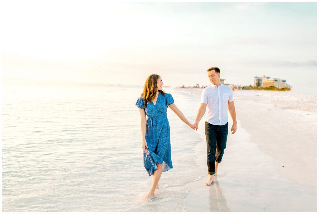 couple walking on beach for engagement photos in florida